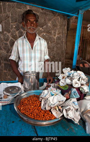 India, Kerala, Palakkad, roadside snack vendor selling packs of Channa Masala, spicy chick peas, at entrance to fort Stock Photo