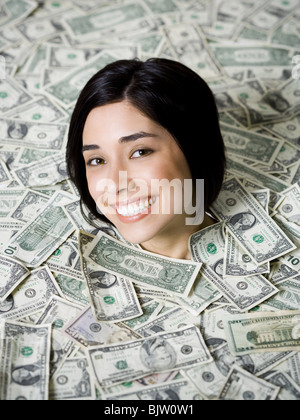 Head of woman emerging from dollar bills Stock Photo