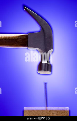 Hammer banging on crooked nail Stock Photo
