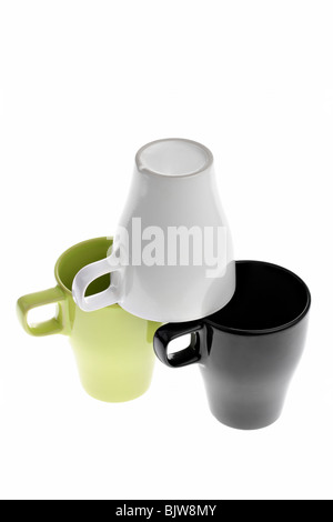 Three coffee cups, one standing upside down on top of two others, isolated on white Stock Photo