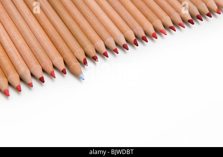 Line of Red Colouring Pencils with One Blue Pencil Sticking Out, on White Background Stock Photo