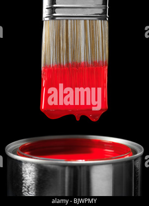 Paintbrush dipped in red paint isolated on black background Stock Photo