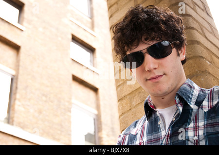 Portrait of young man wearing sun glasses staring at the camera Stock Photo