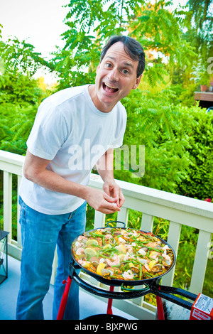 man cooking pizza on outdoor grill Stock Photo