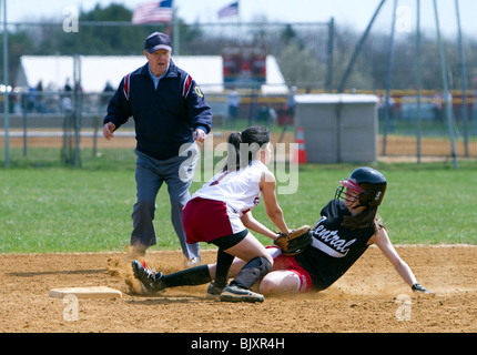 Girls high school softball game. Runner tagged out at second. Umpire calling the play an out. Stock Photo