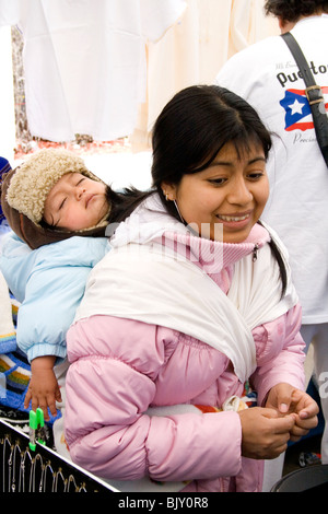 Hispanic woman age 29 carrying her sleeping baby on her back. Cinco de Mayo Fiesta St Paul Minnesota USA Stock Photo