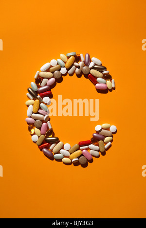 The shaped of the letter C formed with many colorful pills, tablets and capsules