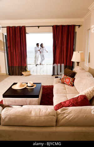 View of middle-aged couple standing on balcony from inside home Stock Photo
