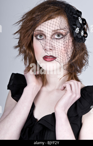 mysterious young woman with black makeup in veil looking away near rose on  blue Stock Photo by LightFieldStudios