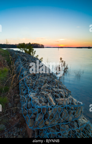 This is an sunset image taken at Old Federal Park on the eastern shore of Lake Lanier near Flowery Branch, GA.  The concrete anchor in the image is used to anchor one end of a string of buoys that mark off the swimming area. Stock Photo