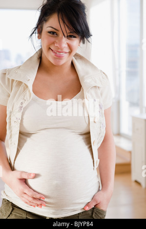 Pregnant Hispanic woman holding stomach Stock Photo