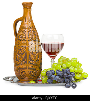 Still life - a clay jug, a glass of wine and grapes isolated on white Stock Photo