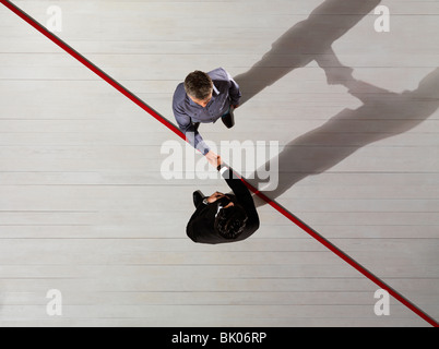Business men Shaking hands over red line Stock Photo