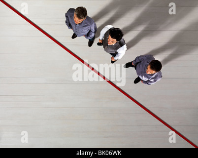 Business men standing by red line Stock Photo