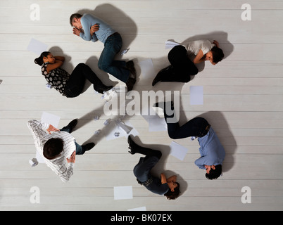Business men and women asleep on floor Stock Photo