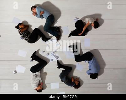 Business men and women asleep on floor Stock Photo