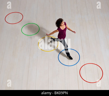 Woman jumping over circles Stock Photo