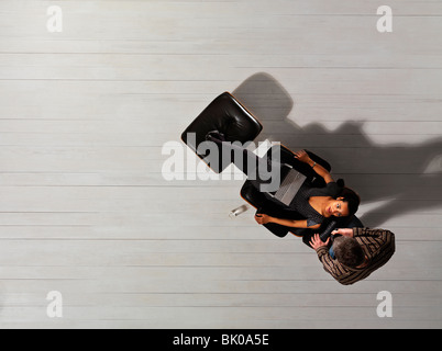 Couple using laptop together on chair Stock Photo