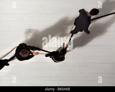Business man leading others with rope Stock Photo