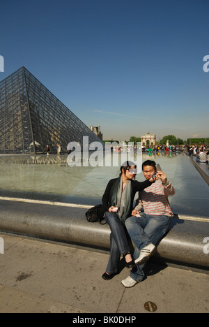 Asian tourist couple taking self portrait at Louvre pond Paris France Stock Photo
