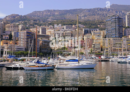 Luxury yachts and boats in Monaco harbor. Mountains and buildings. Stock Photo