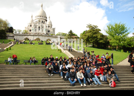 a party of students posing for snapshot in front of Sacre Coeur Paris Stock Photo