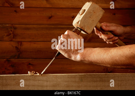 gouge wood chisel carpenter tool hammer in hand working wooden background Stock Photo