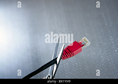 Cutting with wired technology metaphor, ethernet RJ45 cable scissors Stock Photo