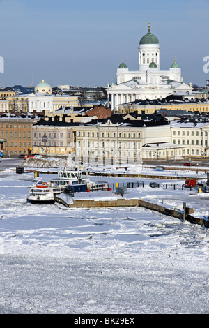 Ice covered Helsinki Harbour with Suomenlinna II berthed in the foreground and Helsinki Lutheran Cathedral raising up behind. Stock Photo