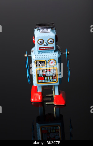 toy robot walking on black reflective surface Stock Photo