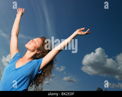 Woman spreading her arms towards the sky Stock Photo