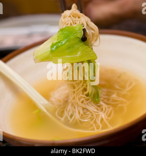 Close up of shrimp wonton and noodle soup eaten with chopsticks at Chi Cafe in Chicago, IL Stock Photo