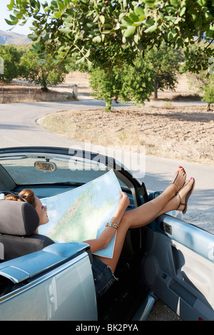 A woman reading a map in a car Stock Photo