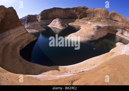 Kayaking (center right) on Lake Powell in Reflection Canyon beneath the reservoir's 110-foot tall 'bathtub ring'. Stock Photo
