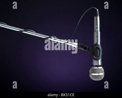 A microphone on a boom over a blue background. Stock Photo