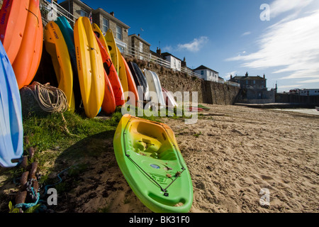 Canoes on the beach in Mousehole harbour, Cornwall, uk Stock Photo