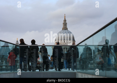 People on Millennium Bridge with the Domed tower of St Pauls Cathedral, London, UK. Stock Photo