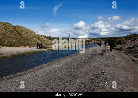 People walking along the banks of the Red River at Gwithian Towans in Cornwall.  Photo by Gordon Scammell Stock Photo
