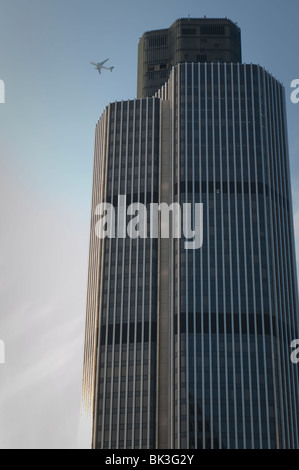 A plane flying close to a Skyscraper building in London. Stock Photo