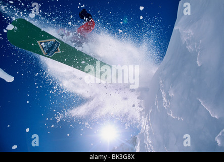 Snowboarding blasting off a cornice in an explosion of snow at Snowbird Resort in the Wasatch Mountains of northern Utah. Stock Photo