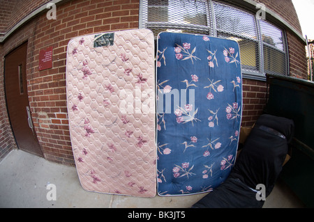 Mattresses wait for bulk pick-up in the trash area of an apartment building in New York Stock Photo