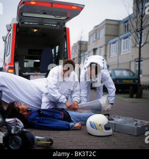 Ambulance and paramedics taking care of teenage girl after accident