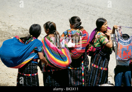 Guatemalan women carrying cargo and children on their backs, Cantel Region, Guatemala Stock Photo