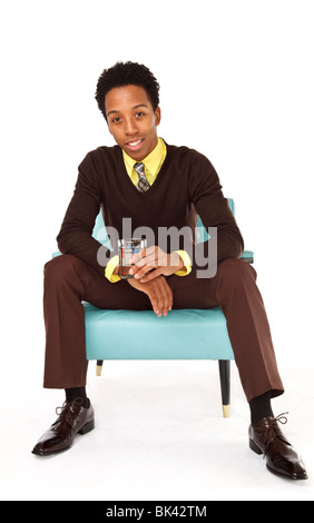 A model-released portrait of a hip, stylish, young african american man sitting in a mid-century modern retro chair. Stock Photo