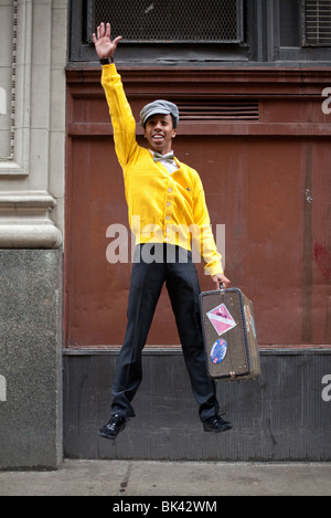 A model-released full-length portrait of a hip, stylish, young african american man jumping with a retro suitcase in his hand. Stock Photo