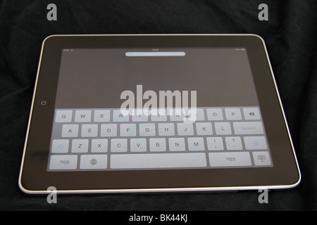 An iPad on black background with the on-screen qwerty keyboard visible Stock Photo
