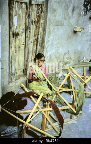 A woman working with handmade wooden frames for spinning thread in Jaipur, India Stock Photo