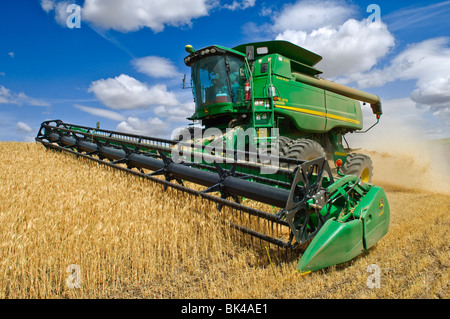 John Deere combine harvesting wheat on hilly fields in the Palouse region of Washington Stock Photo