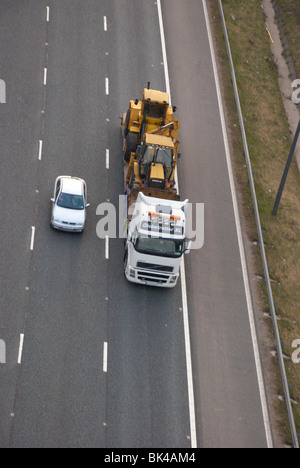 Digger on a lorry on the M62 motorway. Stock Photo