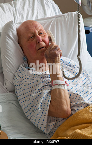 Patient in hospital bed using telephone Wales UK Stock Photo